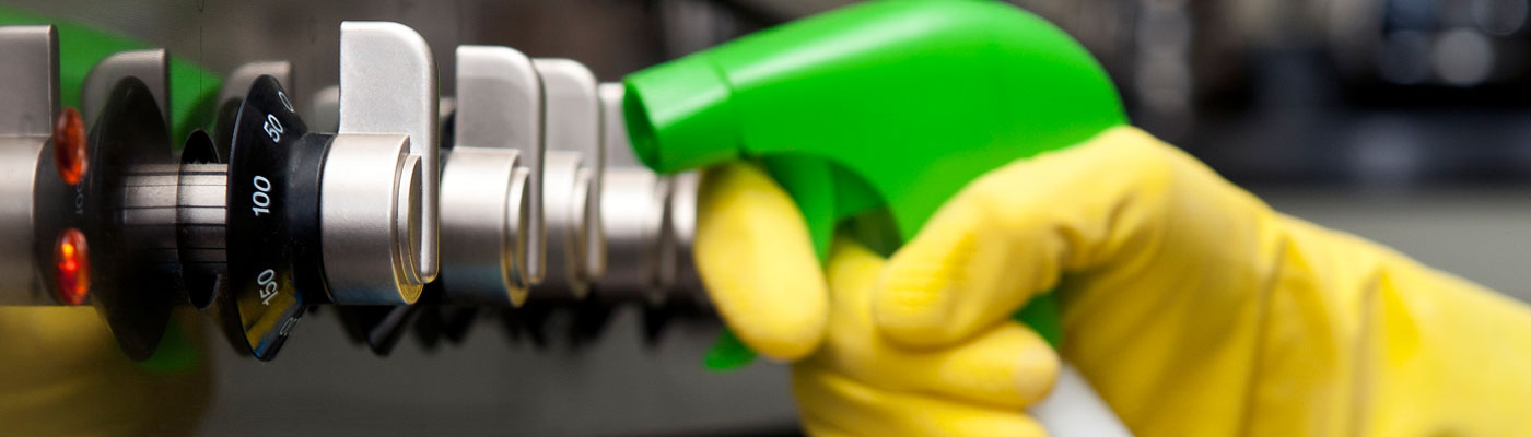 A technician cleaning oven controls with eco cleaning spray